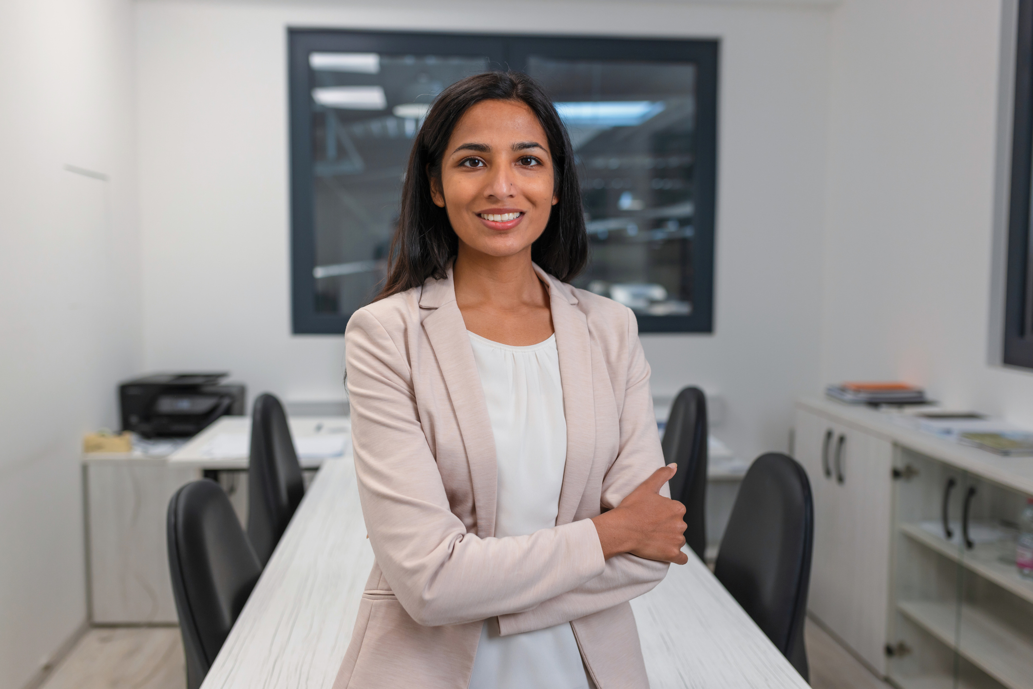 portrait of a young indian woman, a smiling company chief executive in the office